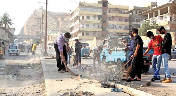 Young volunteers cleaning a street in Karachi