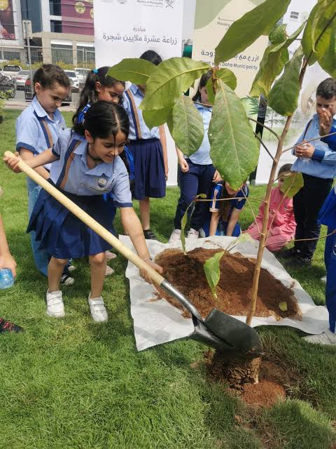 School students planting a tree as part of a community project